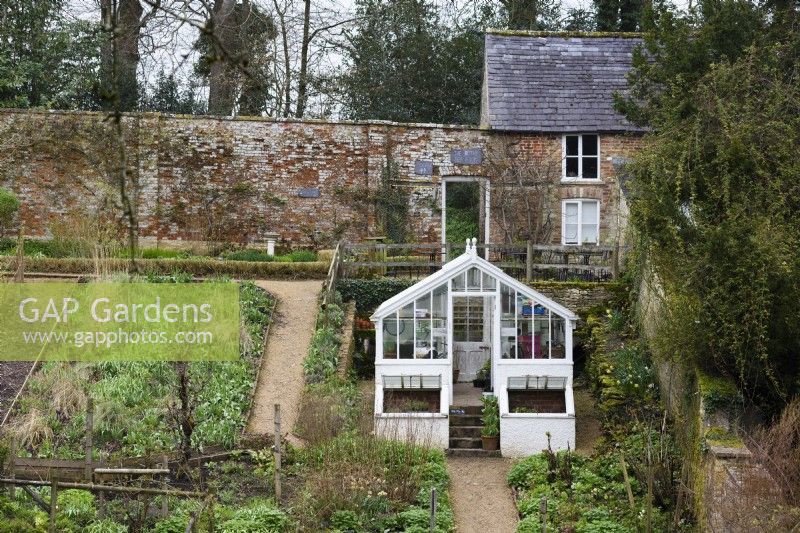 White greenhouse in the walled garden at Cerney House in March