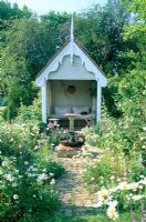 Decorative summerhouse in informal setting with Ox eye daisies at Park Farm in Essex