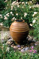 Small bubble fountain made from re-used terracotta container with Rosa 'Penelope' - Pondfield Cottage, Sussex