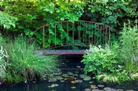 Bridge over pond converted from old swimming pool at Brewery House in Somerset