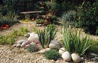 Dry gravel garden with stones and bench at Heathfield in Surrey
