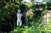 Sharon Osmund's garden. Berkeley. California. Ornaments, sculpture and found objects in small suburban town fantasy garden. 