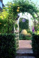 View through metal archway with climbing rose to courtyard in San Francisco, USA
