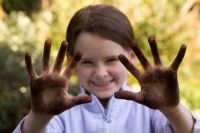 Young girl with compost on hands
