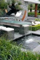 Outdoor seating area with a table water fountain and pool 