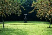 Lawn with circular path and sundial - Malus 'Golden Hornet'