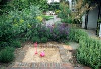 Sand pit edged by brick pavers - Planting to divide the garden and hide the sandpit