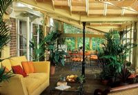 Conservatory interior with houseplants used to divide seating and dining areas