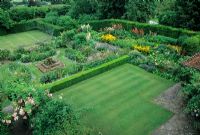Overview of garden with lawn, dividing hedges, borders, tennis court and patio - Restored Gertrude Jeckyll Garden - Manor House, Upton Grey, Hants 




