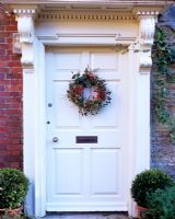 Christmas wreath of Ilex, Hedera and Rosemary on door