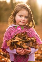 Little girl holding Autumn leaves