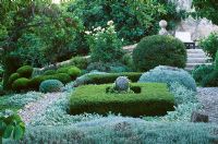 Clipped topiary pine, Buxus and Santolina with Stachys and stone ball - La Chabaude, France 