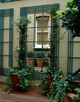 Courtyard with decking, mirror, trellis and brick wall
