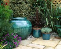 Blue glazed containers with Cordyline and Santolina and Phormiums behind - The Goldfish Garden, Ghelsea 2003  
