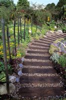 Garden path made from old railway sleepers with gravel fill in