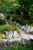 Chinese influenced garden with stone-edged path in shaded walk, Box edging and Diascia - Wiltshire