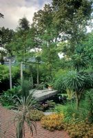 Tropical style suburban garden with raised floating patio area above pool at Silas Mountsier's garden in New Jersey,USA 