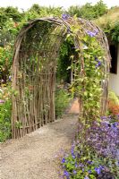 Clematis growing on willow arch over blockley porous clay paving - 'I'll Drink to That' garden, Hampton Court 2007

 