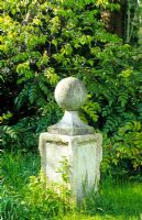 Stone obelisk as focal point in a wild garden
