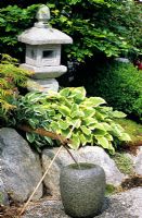 A stone water feature in an oriental garden