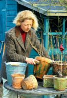Woman cleaning algae off terracotta pots