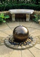 Water feature - Glazed terracotta Golden ball with pebble surround.