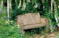 Simple stone seat surrounded by Digitalis