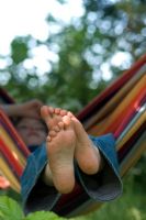 Boy relaxing in a colourful striped hammock
