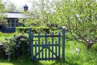 Rustic gate leading to wild flower meadow and orchard
