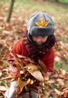 Child playing with autumn leaves