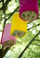 Paper lanterns hanging from trees in garden