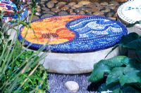Decorative disks of glass and plastic mosaic tiles and plaster in the 'Mediterranean Chillout' garden, RHS Hampton Court Flower Show