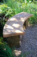 A shaded curved wooden bench in the 'Four Winds Garden', RHS Hampton Court Flower Show