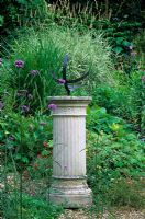 Garden in August with Chilstone Fluted Sundial, Verbena bonariensis and grasses. Designed by Alan Titchmarsh at Barleywood, Hampshire.