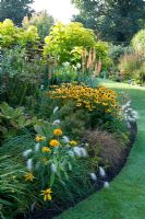 The borders in this garden are filled to maximum with plants that continue to impress because of regular dead-heading - Merriments Gardens, East Sussex  