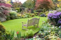 Wooden bench and borders at Eastgrove Cottage garden, Worcestershire