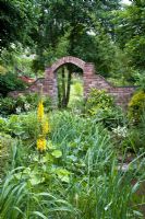 Brick arch and brookside planting at Honeybrook House Cottage, Worcestershire