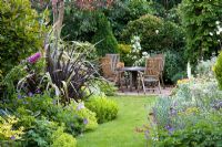 Wooden table and chairs in the cottage garden at Honeybrook House Cottage, Worcestershire