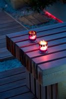 Ornate candle holders with lit candle on western red cedar bench - Roof garden, Holland Park, London 