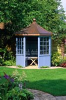 Blue painted summerhouse in the 'Family Retreat' garden at the RHS Hampton Court Flower Show