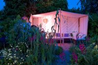 Moroccan inspired garden with drought tolerant planting and Moroccan style tent lit up in the evening