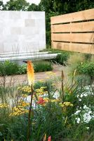 Hemerocallis, Achillea 'Terracotta', Stipa tenuissima and Kniphofia in The Traveller's Garden with Bradstone - Hampton Court Flower Show 2008