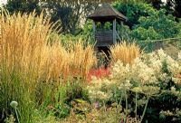 The square garden viewing tower in autumn with Calamagrostis x acutiflora 'Karl Foerster', Persicaria polymorpha and Peucedanum verticillare