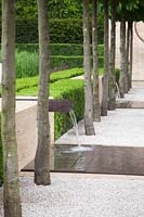 Contemporary water feature with rusted steel chute and shallow pool, under avenue of Carpinus betulus - The Laurent-Perrier Garden, Sponsored by Champagne Laurent-Perrier - Gold medal winner at RHS Chelsea Flower Show 2009