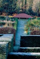 View over Yew hedges to the Grasses Parterre and seat - Veddw House Garden, February 