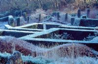 View over the Yew Garden to the Wild Garden and wood from the Grasses Parterre, Beech hedge in foreground - Veddw House Gardens, February 