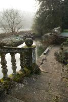Stone balustrades and steps leading down to the river, Heale House Gardens, Wiltshire in frost