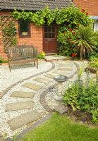 Gravel pathway with sweeping design of slabs leading to front door