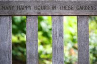 Garden seat with the words 'Many happy hours in these gardens' carved into it 
