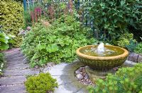 Water feature with circular stone paving around base in pretty secluded suburban garden - High Trees, NGS, Longton, Stoke-on-Trent, Staffordshire